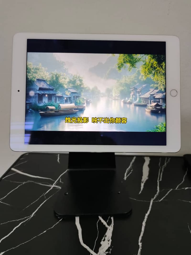 iPad in a black metal anti-theft enclosure on a counter stand, screen on