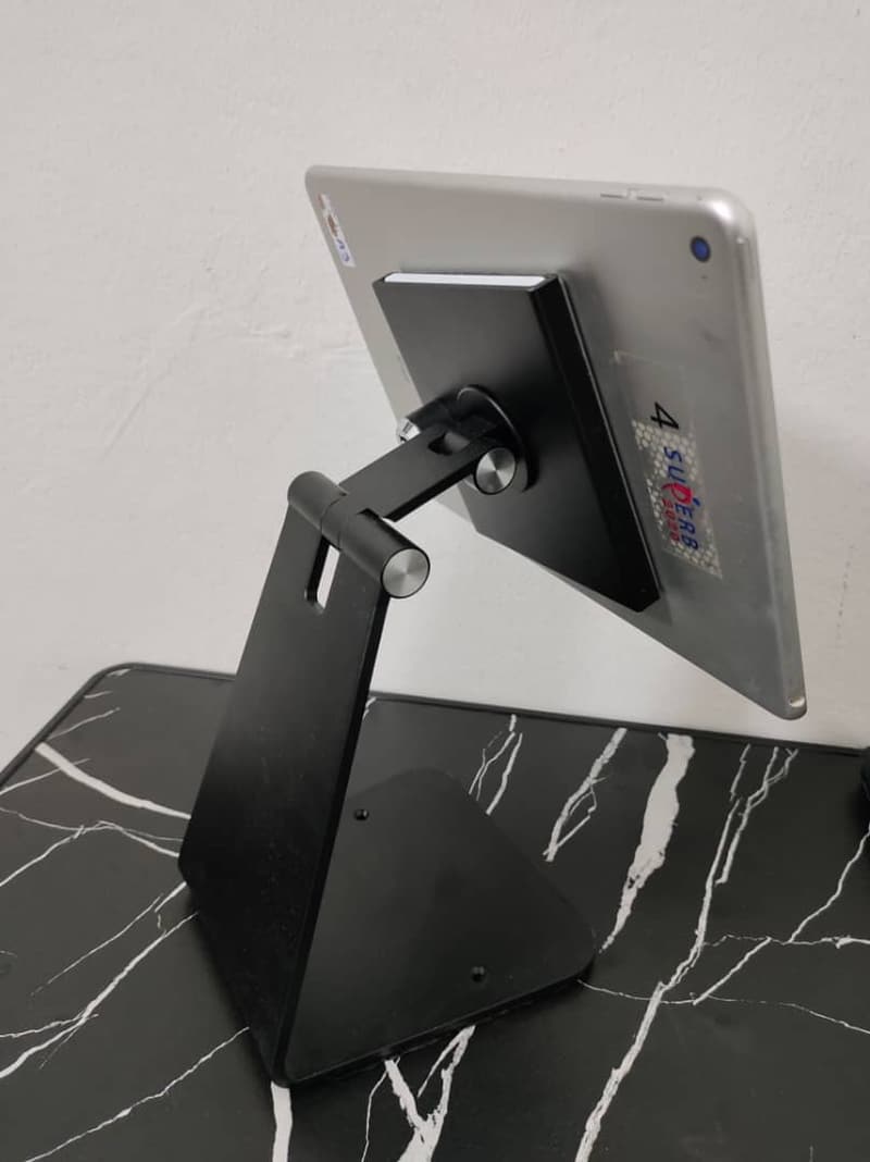 Back view of the frameless table stand showing the articulated arm holding the iPad