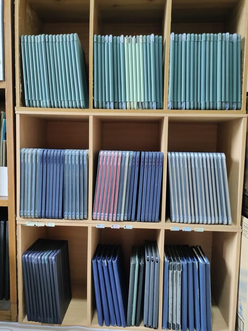 A full wall of shelving holding rows of iPads in coloured cases