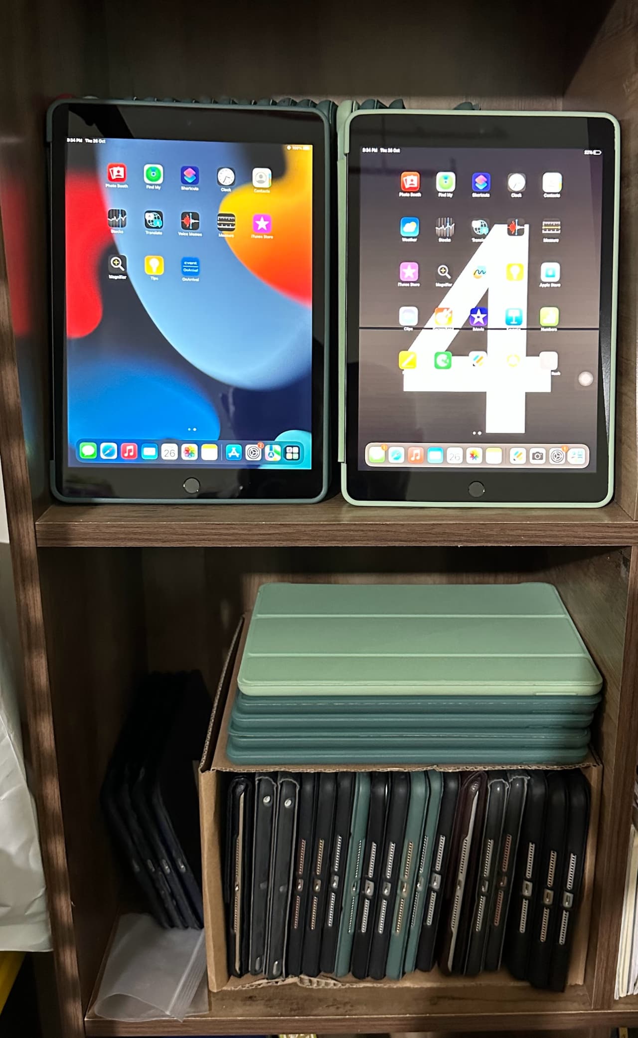 Shelving unit holding iPads alongside stacks of protective cases