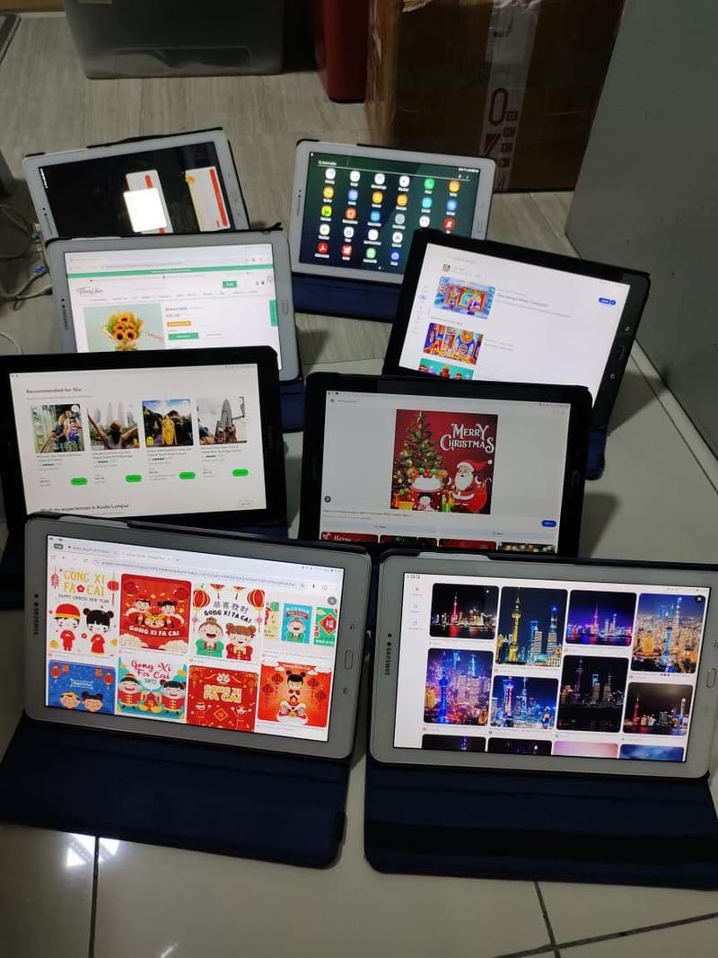 A large group of iPads arranged with screens on, ready for dispatch